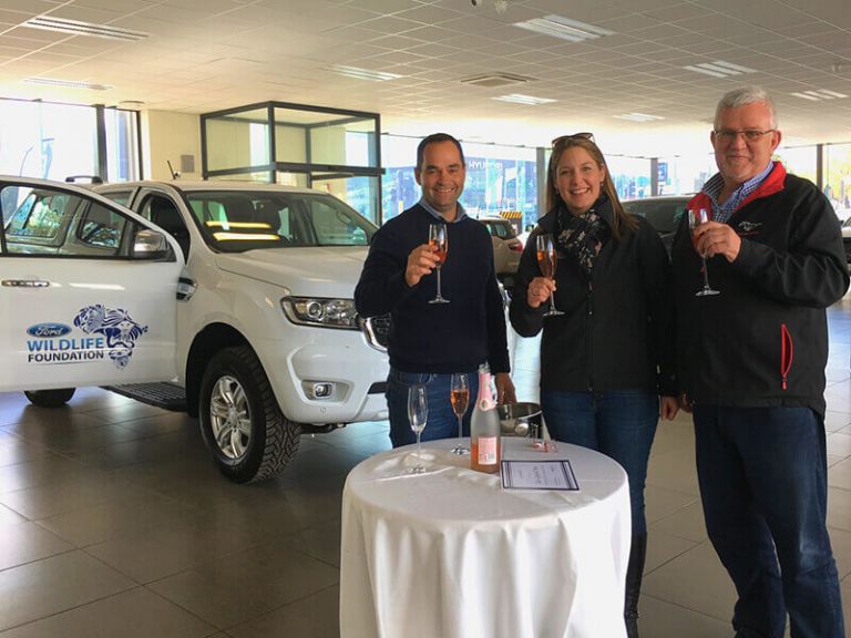 De Villiers Barry and Sakkie Prins of Jaffe&#039;s Ford in Worcester celebrating the new vehicle with Lana Müller, Research and Operations Manager at the Cape Leopard Trust.